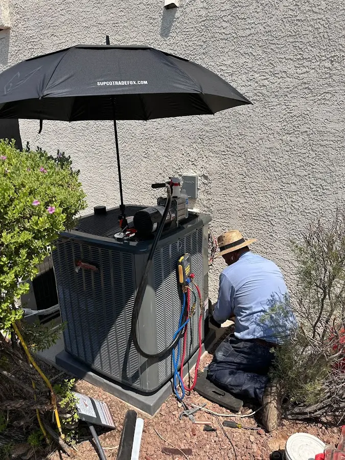 HVAC technician performing outdoor AC maintenance in Kaiminani